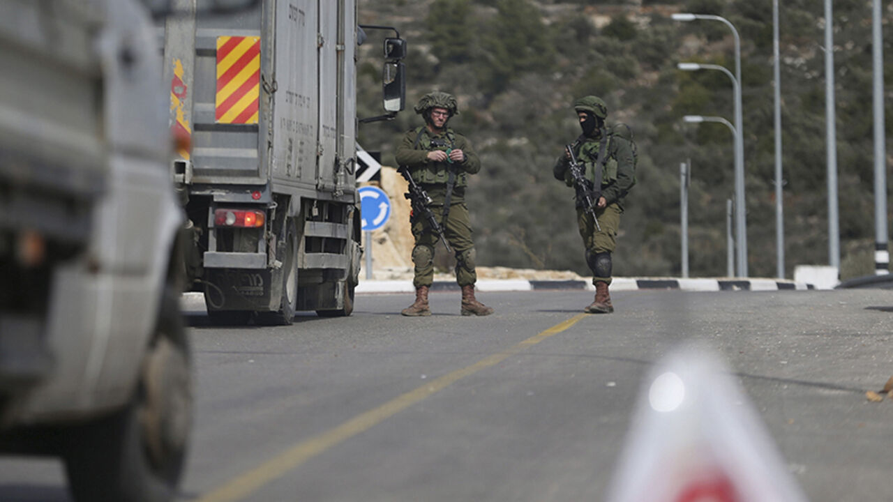 ISRAEL-PALESTINIANS/ Israeli soldiers stand guard as they carry out an identity check on Palestinians at an Israeli checkpoint leading to the West Bank city of Ramallah February 1, 2016. Following Sunday's shooting attack by a Palestinian, Israeli forces have taken security measures allowing only residents of Ramallah to enter the city, with a temporary closure for exit except for humanitarian cases, an Israeli military spokeswoman said. REUTERS/Mohamad Torokman - RTX24W9B