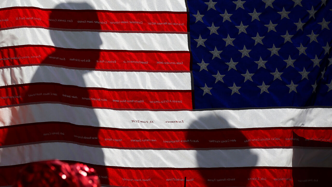 FLORIDA-SHOOTING/ The names of Pulse night club shooting victims are embroidered on a U.S. flag at a makeshift memorial in Orlando, Florida, U.S., June 17, 2016. REUTERS/Carlo Allegri - RTX2GV5Z