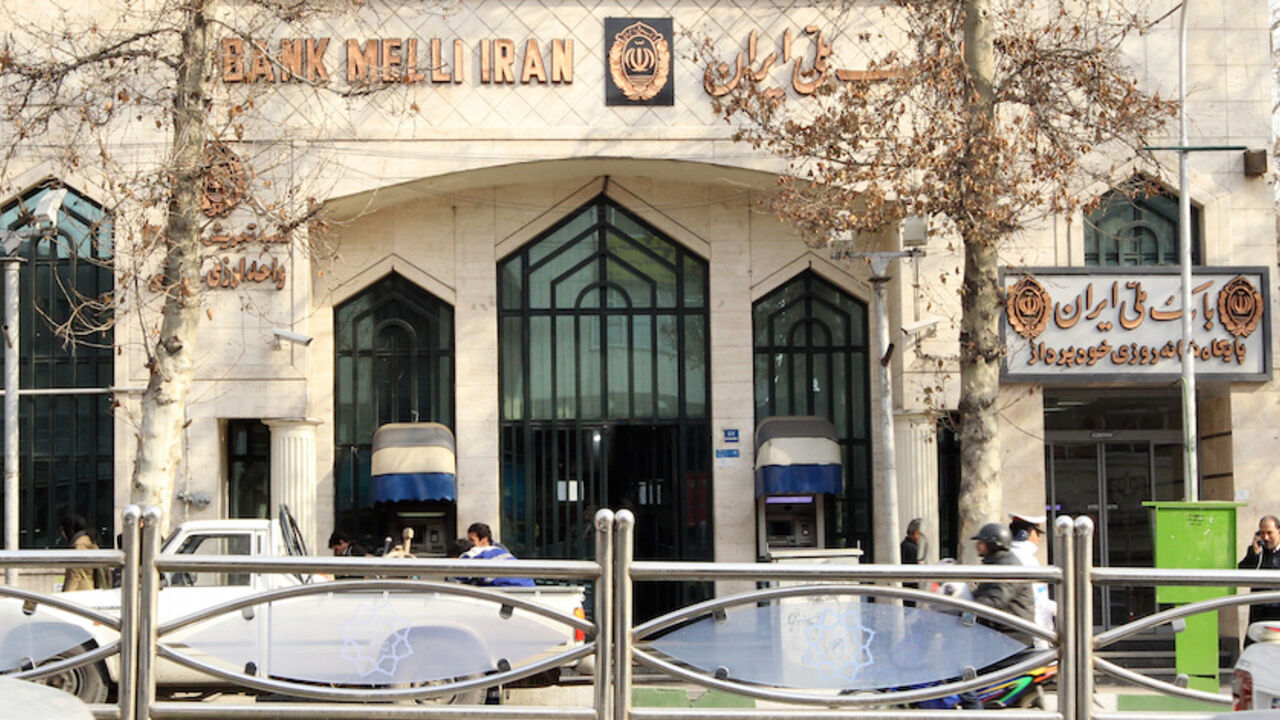Nic6051867 Iranians walk past a branch of Bank Melli in Tehran on January 23, 2012. Top European Union diplomats are meeting in Brussels to tighten existing sanctions on Iran by banning imports of Iranian crude as well as targeting finance, petrochemicals and gold to pressure the country. AFP PHOTO/ATTA KENARE (Photo credit should read ATTA KENARE/AFP/Getty Images)