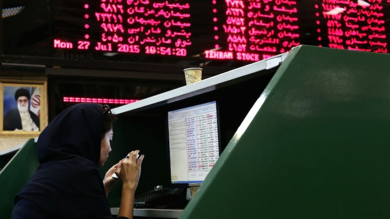 IRAN-ECONOMY-STOCKS An Iranian dealer checks her mobile phone next to stock market activity boards at the stock exchange in the capital Tehran on July 27, 2015. Iran's central bank chief said that Iran has assets of $29 billion in overseas banks that could be unlocked under a nuclear deal struck on July 14, far less than reported estimates of over $100 billion. AFP PHOTO / BEHROUZ MEHRI (Photo credit should read BEHROUZ MEHRI/AFP/Getty Images)