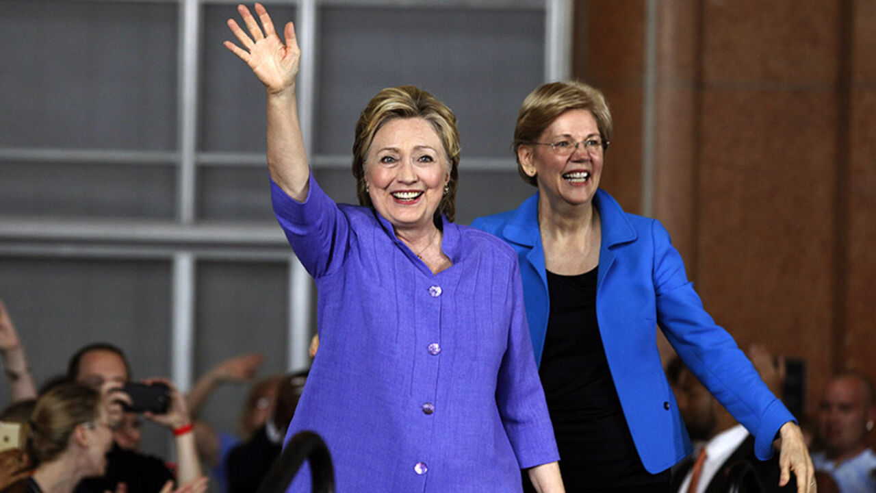 91287654 CINCINNATI, OH- JUNE 27: Democratic Presidential candidate Hillary Clinton (L) and Senator Elizabeth Warren (R) wave to the crowd before a campaign rally at the Cincinnati Museum Center at Union Terminal June 27, 2016 in Cincinnati, Ohio. Warren is helping Clinton campaign in Ohio. (Photo by John Sommers II/Getty Images)