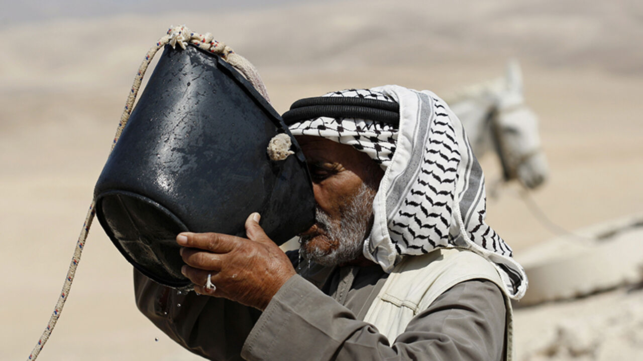 PALESTINIANS-ISRAEL/CISTERNS Bedouin Falah Hedawa drinks water drawn from a rainwater collection cistern in the Rashayida area, in the desert between the West Bank town of Bethlehem and the Dead Sea July 25, 2011. The cisterns which dot the desert beyond Bethlehem, many of them restored to full working order in the last few years, have for centuries harvested winter rain to provide shepherds and their flocks with water through summer. Israel has demolished 20 cisterns in the West Bank in the first half of this year, according to the U.