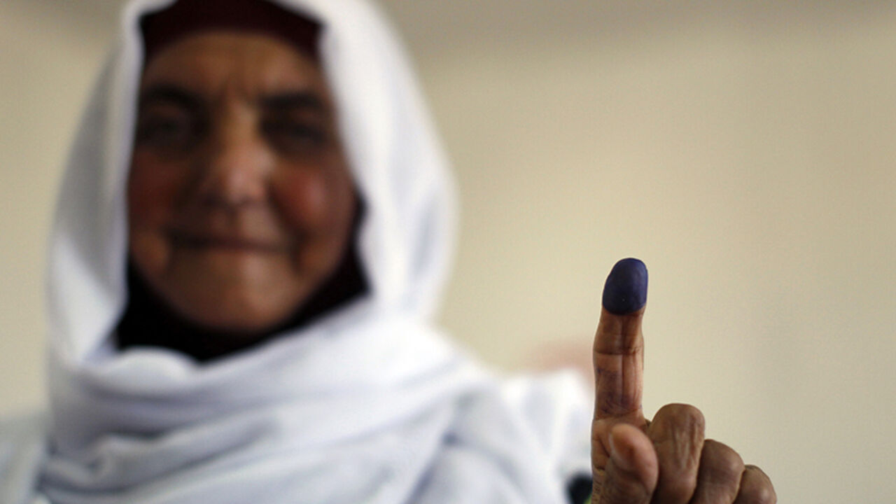 PALESTINIANS/ELECTIONS A Palestinian woman shows her ink-stained finger after casting her ballot for municipal elections at a polling station in the West Bank village of Shiyoukh, north of Hebron October 20, 2012. Palestinians voted in local elections in the Israel-occupied West Bank on Saturday, their first vote for six years and one with little choice, out of step with democratic revolutions elsewhere in the Arab world. REUTERS/Ammar Awad (WEST BANK - Tags: ELECTIONS POLITICS) - RTR39D2R