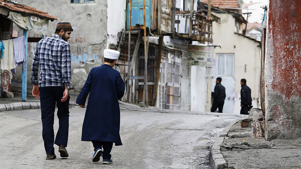TURKEY-DAILYLIFE/ A man and a boy walk a long a street after they attending Friday prayers at Hacibayram district of Ankara November 21, 2014. Picture taken November 21, 2014. REUTERS/Umit Bektas (TURKEY - Tags: SOCIETY) - RTR4GIZA