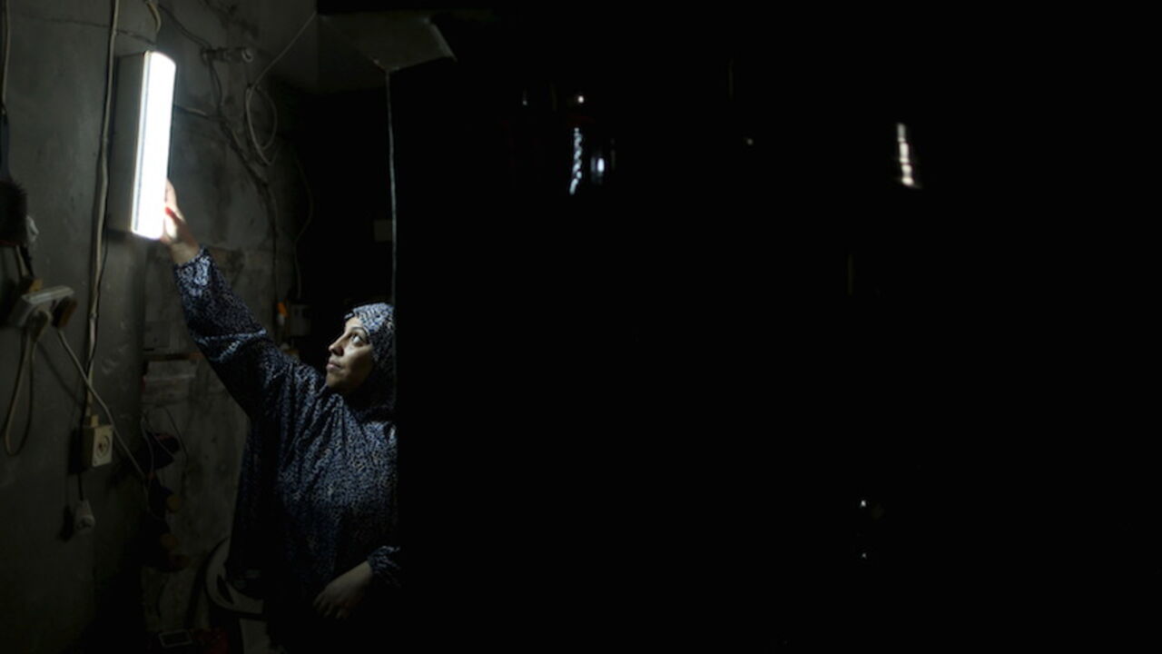 A Palestinian woman hangs a torch inside her house during power cuts at Shatti (beach) refugee camp in Gaza City September 15, 2015. Power has been provided to different areas in the impoverished coastal territory in six-hour shifts as Gaza's lone power plant shut its generators on Saturday due to a fuel shortage, energy officials said. Electricity is also supplied to the Gaza grid through power lines from Israel and Egypt. Gaza's plant provides electricity to two-thirds of its population. REUTERS/Mohammed 