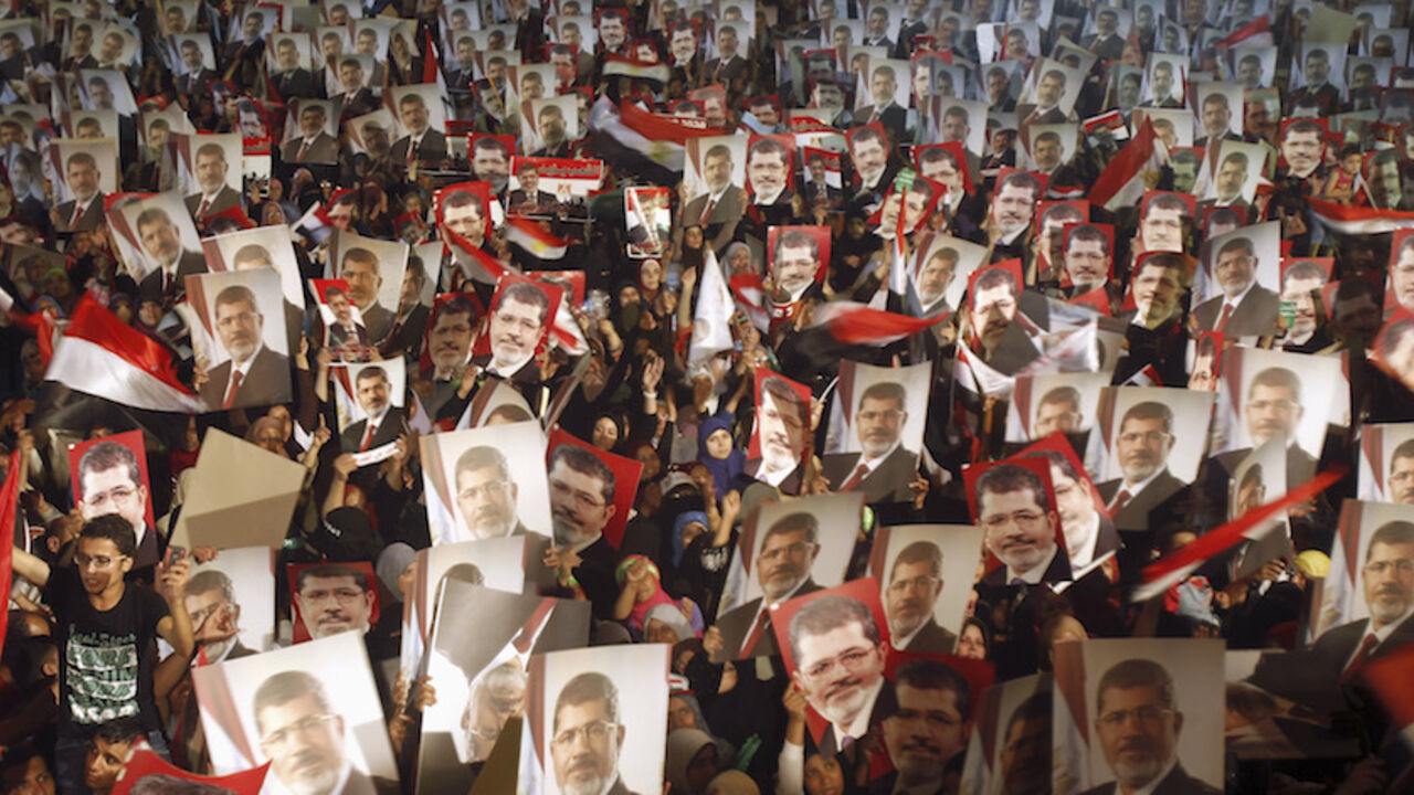 Members of the Muslim Brotherhood and supporters of Egypt's President Mursi hold pictures of him as they react after the Egyptian army's statement was read out on state TV, at the Raba El-Adwyia mosque square in Cairo Members of the Muslim Brotherhood and supporters of Egypt's President Mohamed Mursi hold pictures of him as they react after the Egyptian army's statement was read out on state TV, at the Raba El-Adwyia mosque square in Cairo July 3, 2013. Egypt's armed forces overthrew elected Islamist President Mursi on Wednesday and announced a political transition with the support of a wide range of political, religious and youth leaders. A statement published in Mursi's name on his official Facebook page after head of