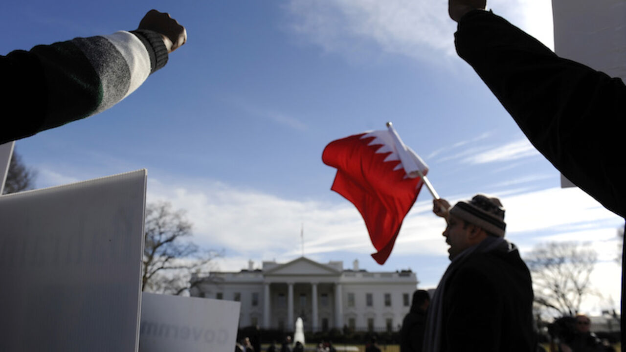 BAHRAIN/ Demonstrators raise their fists as they protest against Bahrain's ruling Al-Khalifa family, in front of the White House in Washington February 20, 2011. REUTERS/Jonathan Ernst (UNITED STATES - Tags: POLITICS CIVIL UNREST) - RTR2IVSG