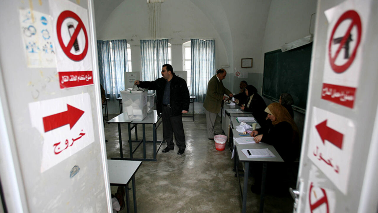 MIDEAST Palestinians cast their vote at a polling station in the West Bank town of Jenin, January 25, 2006. Palestinians voted in their first parliamentary elections in a decade on Wednesday, a ballot that could bring the militant Islamic Hamas movement into government for the first time. REUTERS/Ammar Awad - RTR18X2V