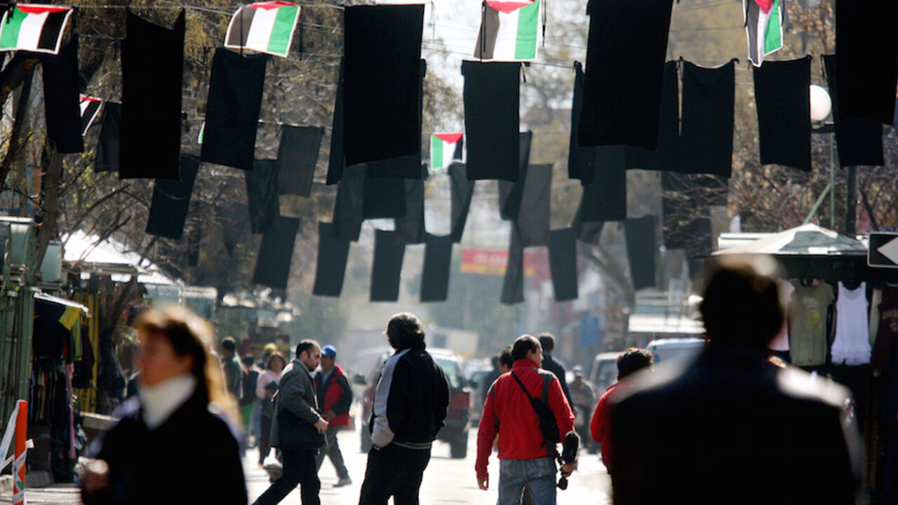 CHILE Pedestrians walk along a street decorated with black and Palestine flags next to an orthodox church in the Patronato neighbourhood in Santiago August 7, 2006, where members of the Palestinian community attended a mass against Israel's military offensive in Lebanon and Gaza. REUTERS/Ivan Alvarado (CHILE) - RTR1G6L1