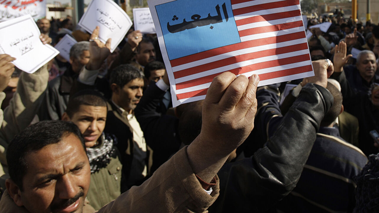 IRAQ-POLITICS/BAATH A protester holds up a poster symbolizing the U.S. flag which reads the word of "Baath" during a rally against the former Baath Party return in Baghdad, February 7, 2010. Iraq's Shi'ite parties held emotional demonstrations on Sunday and vowed to purge loyalists of Saddam Hussein's outlawed Baath party as tensions over a list of candidates banned from a March election soared. REUTERS/Saad Shalash (IRAQ - Tags: CIVIL UNREST POLITICS) - RTR29X72