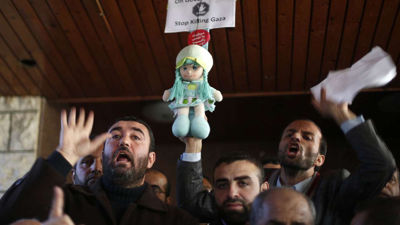 Palestinian Hamas-hired employees shout slogans after breaking past the gate of the Palestinian cabinet headquarters to demand their pay, in Gaza City January 13, 2015. The Palestinian unity government, based in the West Bank city of Ramallah, infuriated public workers on Hamas's payroll by saying it would vet them before paying out salaries - a process that could take months.    REUTERS/Suhaib Salem (GAZA - Tags: POLITICS SOCIETY BUSINESS EMPLOYMENT) - RTR4L86Z