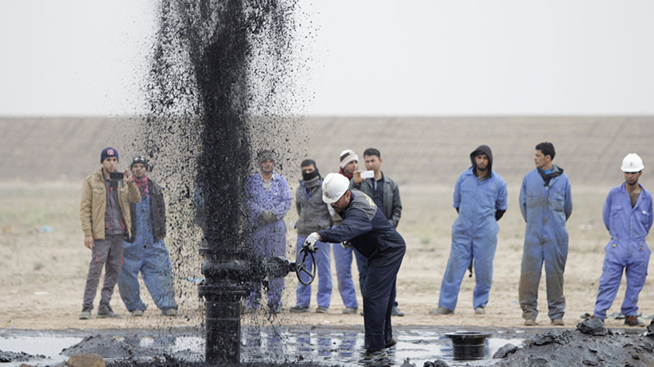 IRAQ-OIL/STORAGE Iraqi workers stand near a pipeline as it ejects oil at Al Tuba oil field in Basra, southeast of Baghdad February 19, 2015. Iraq plans to increase its southern oil storage capacity to 15 million barrels by the end of 2015, to help cope with export bottlenecks caused by bad weather and to absorb rising production, a senior official said on Thursday. REUTERS/Essam Al-Sudani (IRAQ - Tag - Tags: BUSINESS ENERGY) - RTR4QAYT