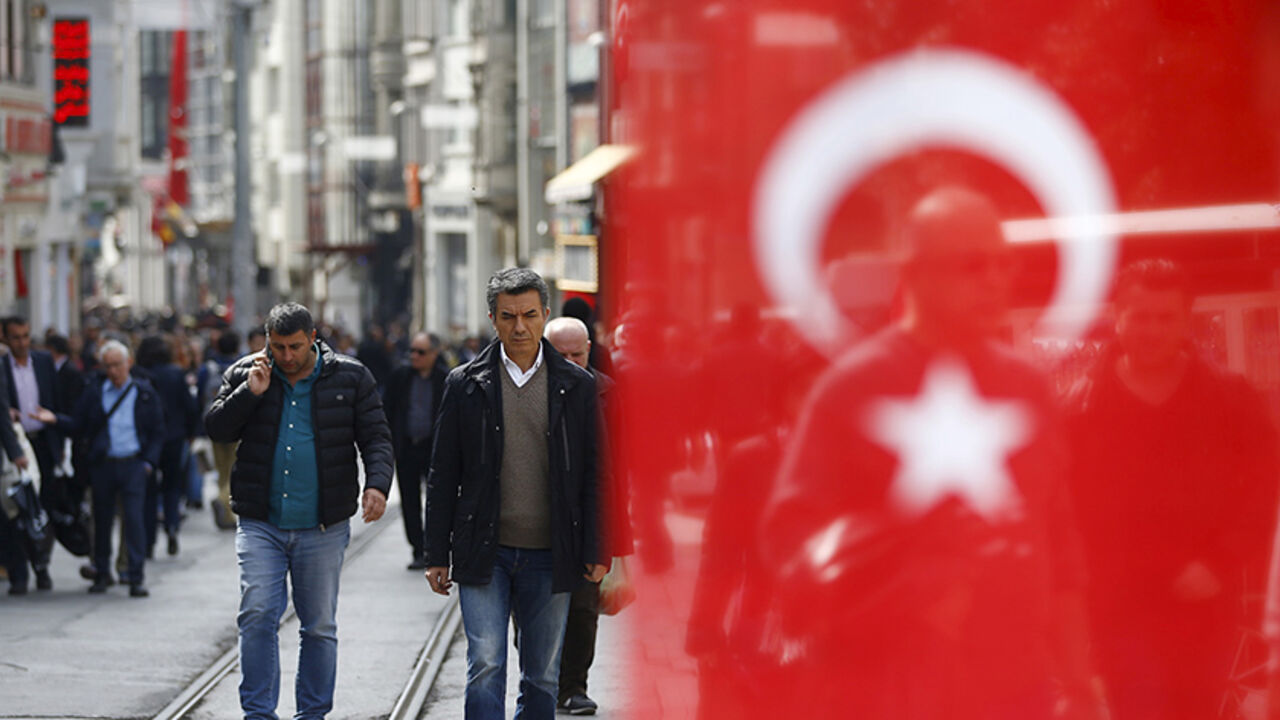 TURKEY-SECURITY/TOURISM People stroll at Istiklal street, a major shopping and tourist district, in central Istanbul, Turkey March 22, 2016. A Turkish flag, which is placed on the stall of a street vendor, is seen on the right. REUTERS/Osman Orsal - RTSBZAH
