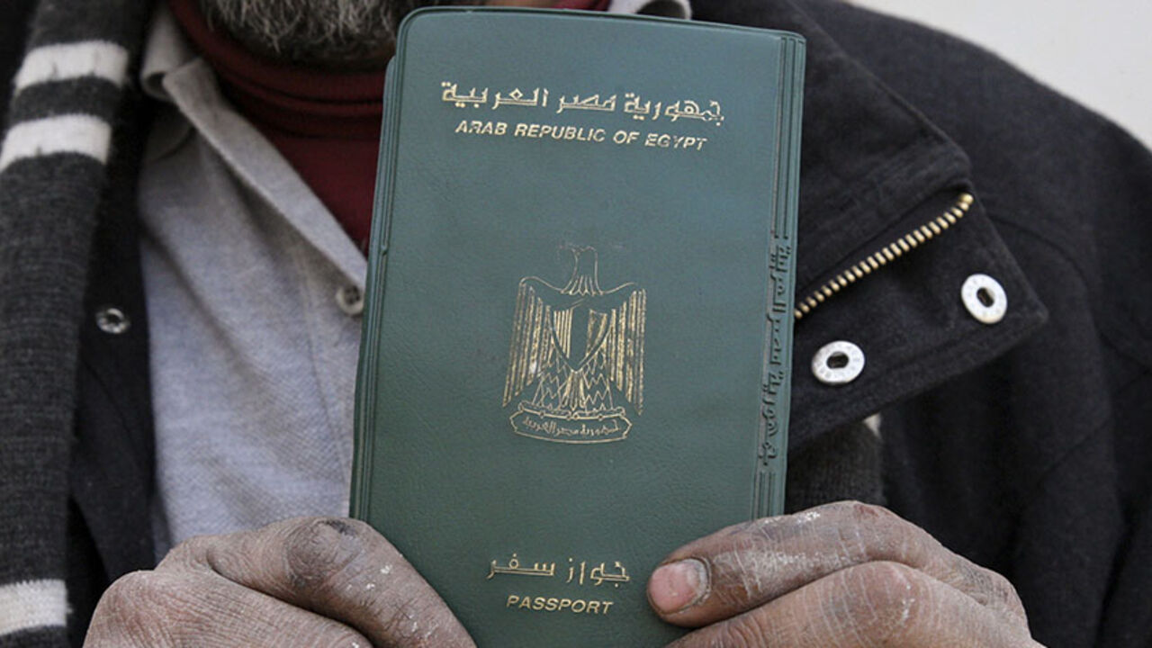 EGYPT-JORDAN/ An Egyptian man shows his passport after voting in a referendum on his country's new constitution at the Egyptian embassy in Amman January 9, 2014. Egyptians living outside the country on Wednesday began voting in a referendum on the new constitution. The referendum marks the first time Egyptians have voted since the removal of President Mohamed Mursi in July, and is seen as much as a public vote of confidence on the roadmap and army chief Abdel Fattah al-Sisi as the constitution itself. REUTERS/Majed Jaber