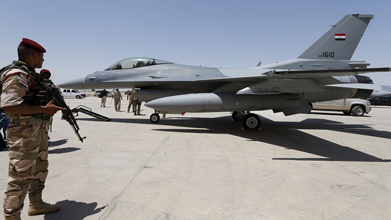 MIDEAST-CRISIS/IRAQ An Iraqi solider stands guard near a F-16 fighter jet during an official ceremony to receive four of these aircrafts from the U.S., at a military base in Balad, Iraq, July 20, 2015. REUTERS/Thaier Al-Sudani - RTX1L2B2