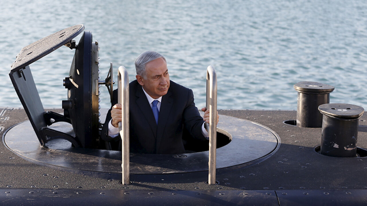 ISRAEL-ARMS/ Israeli Prime Minister Benjamin Netanyahu climbs out after a visit inside the Rahav, the fifth submarine in the Israeli Navy's fleet, after it arrived in Haifa port January 12, 2016. The Dolphin-class submarines, widely believed to be capable of firing nuclear missiles, were manufactured in Germany and sold to Israel at deep discounts as part of Berlin's commitment to shoring up the security of the country set in part as a haven for Jews who survived the Holocaust. REUTERS/Baz Ratner - RTX221FW