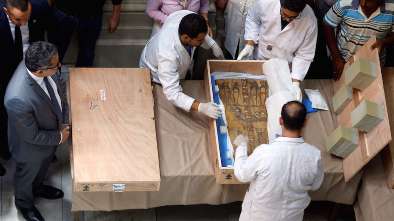 EGYPT-ANTIQUITIES/ Egyptian Minister of Antiquities Khaled El Enany (L) and antiquities officials uncrate a sarcophagus lid during a ceremony after its repatriation from Israel at the Egyptian Museum in Cairo, Egypt June 21, 2016. REUTERS/Amr Abdallah Dalsh - RTX2HE90