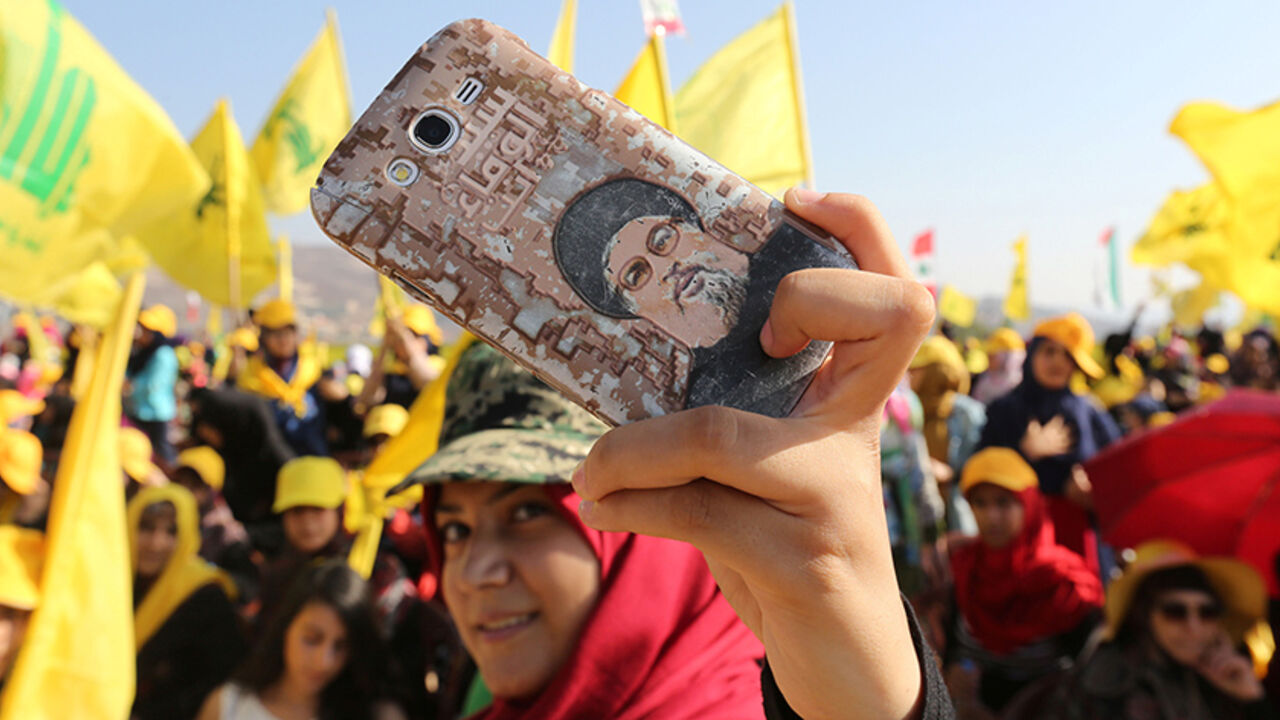 A Hezbollah supporter shows off a picture of Lebanon's Hezbollah leader Sayyed Hassan Nasrallah on her phone during a rally marking the 10th anniversary of the end of Hezbollah's 2006 war with Israel, in Bint Jbeil, southern Lebanon August 13, 2016. REUTERS/Aziz Taher - RTX2KKE3