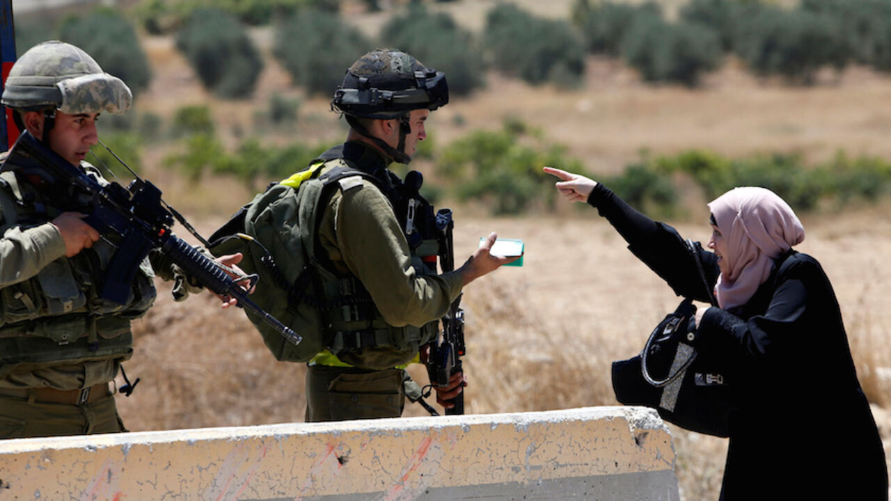 A Palestinian woman argues with Israeli army soldiers as she is searched at a checkpoint during clashes in the West Bank Al-Fawwar refugee camp, south of Hebron August 16, 2016. REUTERS/Mussa Qawasma     TPX IMAGES OF THE DAY      - RTX2L7Q9