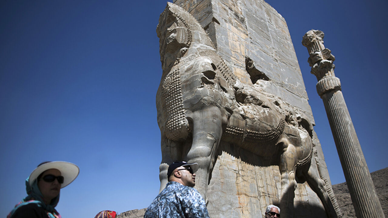 Nic6373454 An Iranian family look at the "Gate of All Nations" at the ancient Persian city of Persepolis near Shiraz in southern Iran on September 26, 2014. Persepolis, is one of the greatest architectural complexes of the ancient world, built atop a huge limestone platform. It was the main royal residence and ceremonial center of the Achaemenid empire of Persia (550-330 BC), but was later burned and plundered by Alexander the Great in 330 BC. AFP PHOTO/BEHROUZ MEHRI (Photo credit should read BEHROUZ MEHRI/AFP/