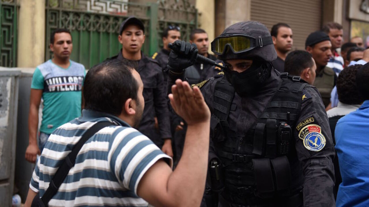 AFP_A83H7 A journalist scuffles with a policeman during a protest to demand the sacking of the interior minister on May 4, 2016 outside the Journalists' Syndicate headquarters in Cairo, after an unprecedented police raid to arrest two reporters.
Egyptian police stormed the headquarters of the journalists' association in central Cairo on May 1, 2016 and arrested two journalists, Amr Badr and Mahmud el-Sakka, for incitement to protest. / AFP / MOHAMED EL-SHAHED (Photo credit should read MOHAMED EL-SHAHED/AFP/Ge