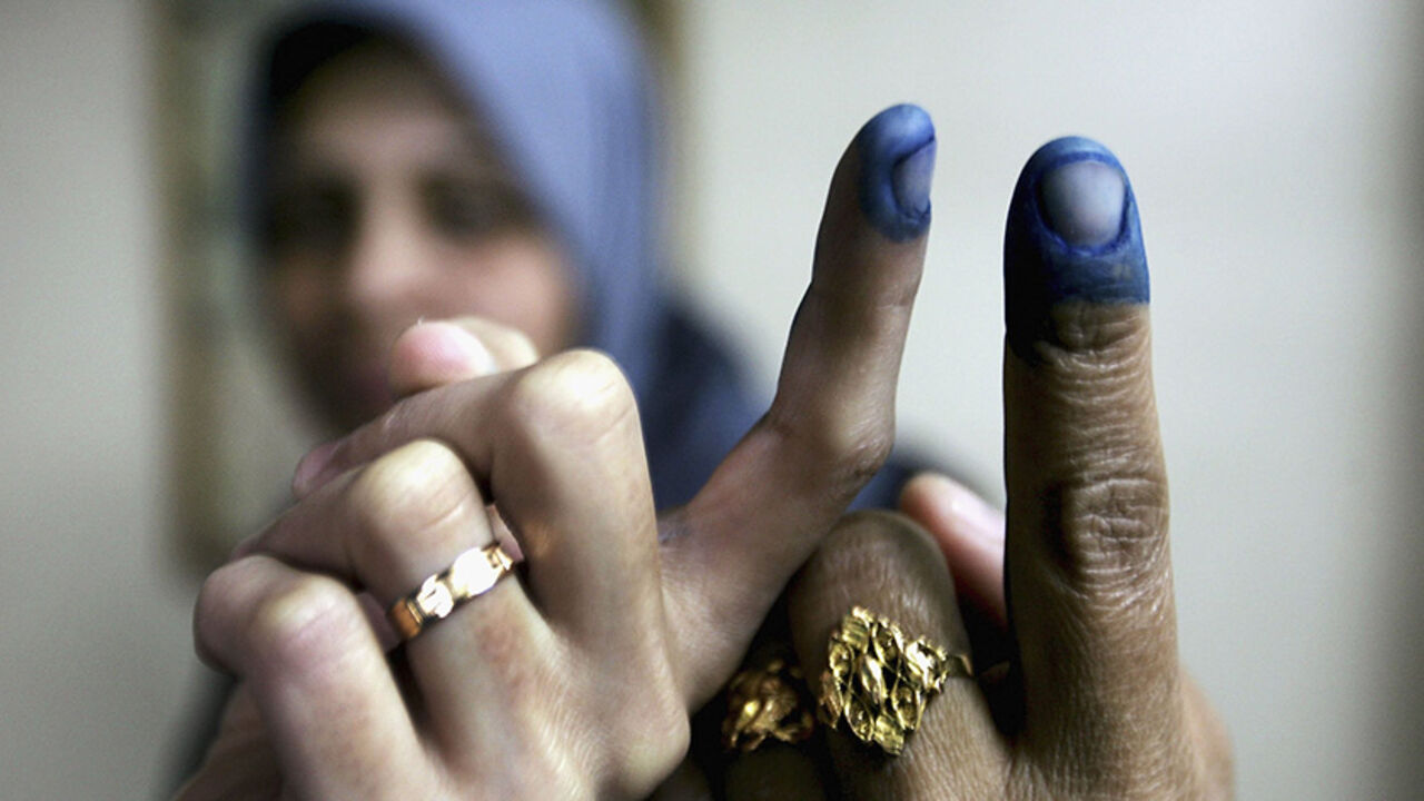 56656153AK005_Election GAZA CITY, GAZA STRIP - JANUARY 25: Palestinian women show their inked fingers after voting in the Palestinian legislative election at a UN school which is being used as a polling station, January 25, 2006, in Gaza City, Gaza Strip. The newly elected Palestinian Legislative Council (PLC) will be expanded, and half of the seats will be allotted by proportional representation of all parties that gather more than two percent of the vote. (Photo by Abid Katib/Getty Images)