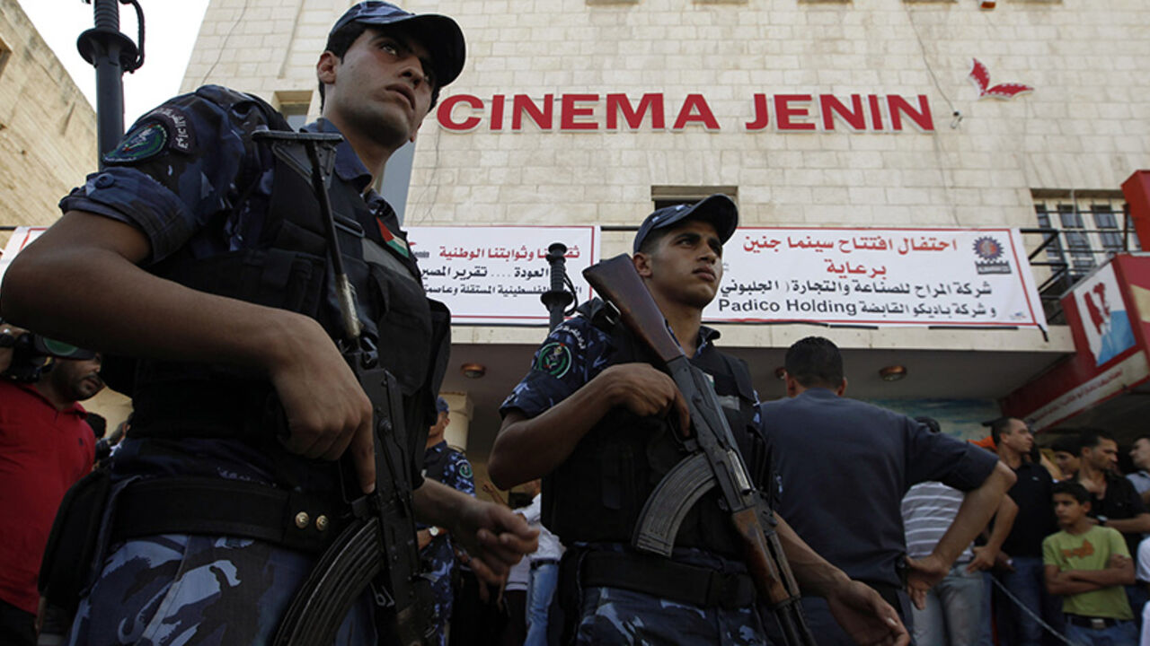 PALESTINIANS-ISRAEL/ Palestinian police stand outside the Cinema Jenin movie theatre in the West Bank city of Jenin August 5, 2010. The only cinema in Jenin, closed for more than 20 years, reopened on Thursday following two years of restoration work. REUTERS/Ammar Awad (WEST BANK - Tags: SOCIETY IMAGES OF THE DAY) - RTR2H2GC