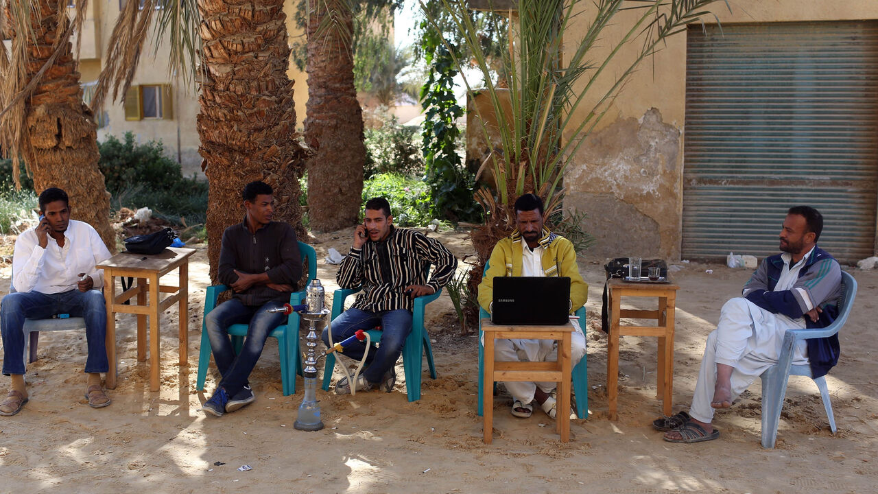 EGYPT-DAILYLIFE/WIDERIMAGE Men smoke and use their mobile phones as they sit at a small cafe in Siwa, November 22, 2014. Residents of Siwa have been hurt by declining tourism in Egypt, which received 9.5 million tourists last year, down from over 14.7 million tourists in 2010, before the uprising that ousted autocrat Hosni Mubarak. Nationwide, the situation is gradually improving and the government says tourism could recover to pre-crisis levels next year if regional turmoil spares Egypt. But Siwa, located just 50 km (30 miles) from