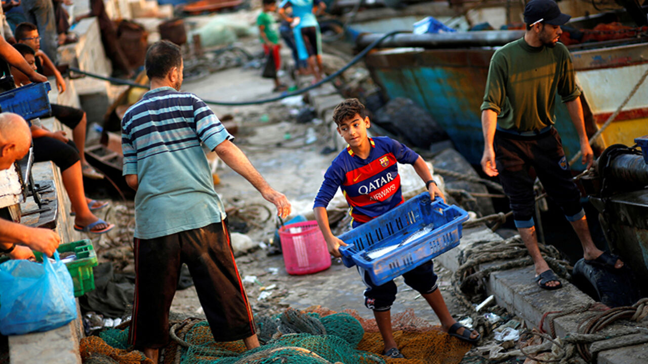ISRAEL-PALESTINIANS/FISHING A Palestinian boy carries a container containing fish as he works with fishermen at the seaport of Gaza City September 26, 2016. Picture taken September 26, 2016. REUTERS/Mohammed Salem - RTSPO9E