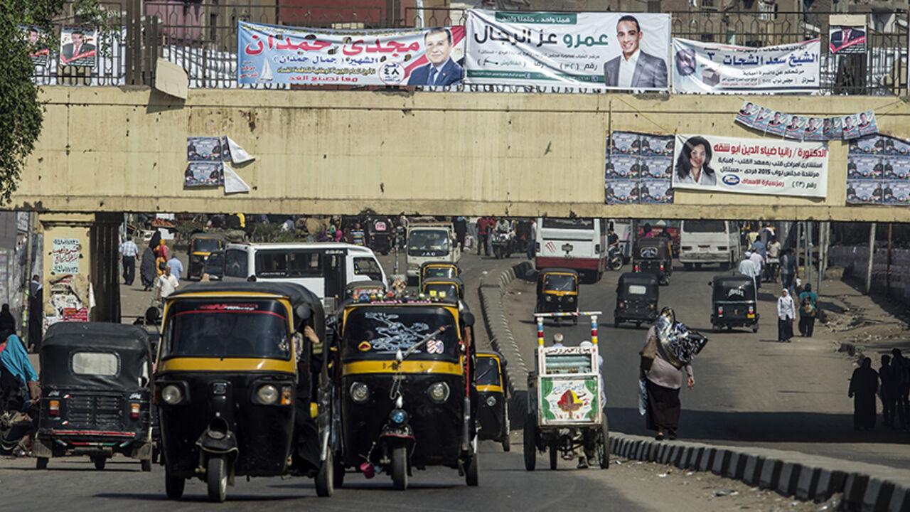 Nic6497089 Egyptian drive rickshaws also known as "Tuk-tuks" along a road bearing portraits of candidates for the upcoming parliamentary elections in the Imbaba district of the Egyptian capital, Cairo, on October 15, 2015. Egyptians begin voting on the weekend for a parliament expected to step firmly in line behind President Abdel Fattah al-Sisi, who has crushed all opposition since ousting his Islamist predecessor in 2013. AFP PHOTO / KHALED DESOUKI (Photo credit should read KHALED DESOUKI/AFP/Getty Images)
