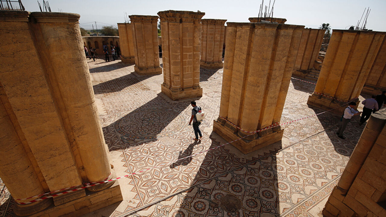 AFP_HB7OL A Palestinian man removes weeds from the Hisham's Palace archaeological site, located five kilometres north of the West Bank city of Jericho, on October 20, 2016, after the mosaic in the palace was uncovered and readied for display. / AFP / ABBAS MOMANI (Photo credit should read ABBAS MOMANI/AFP/Getty Images)