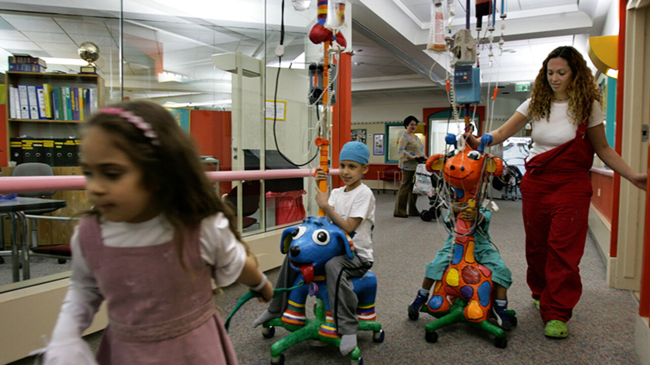 MIDEAST Amit (2nd L), a 7 year old cancer patient, sits on his intravenous drip stand decorated with an animal figure at Schneider Children's Medical Center in Petah Tikva March 23, 2006. The hospital offers art therapy for children undergoing cancer treatments as a way to make their treatments more friendly. REUTERS/Ronen Zvulun - RTR17JJ2