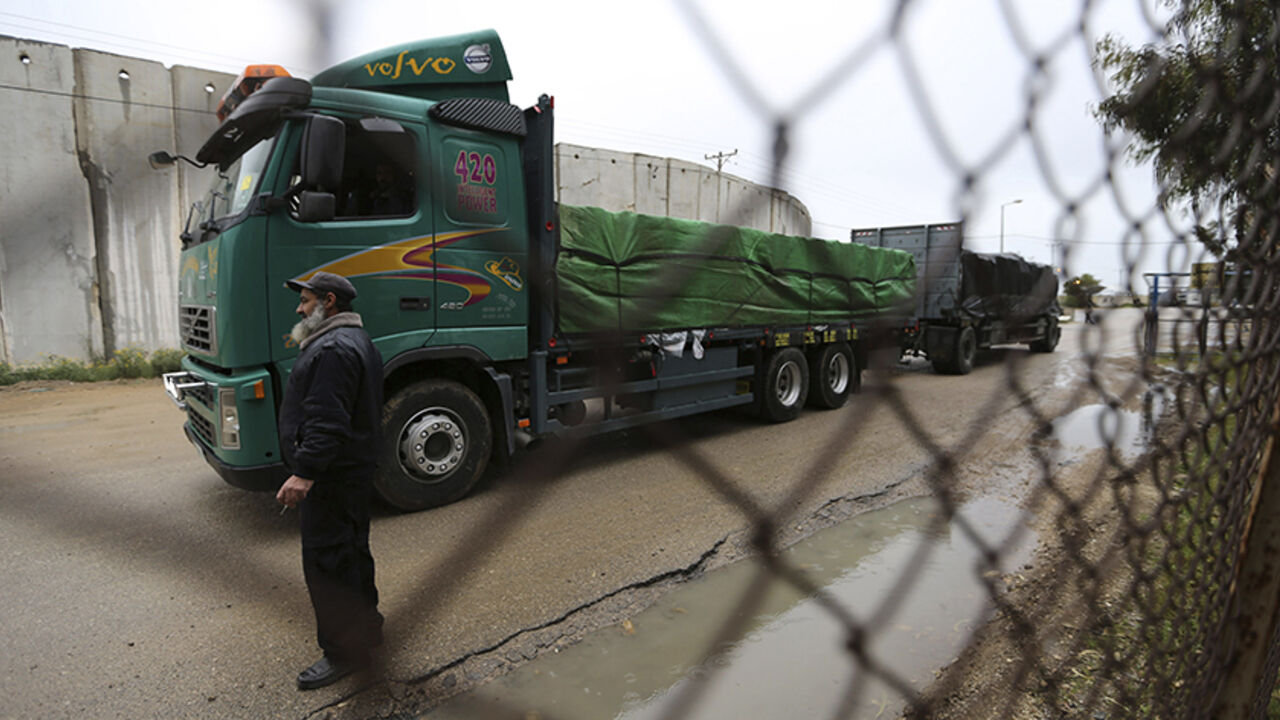 ISRAEL-PALESTINIANS/EXPORTS A Palestinian policeman stands guard as a truck loaded with fruits and vegetables waits to cross into the Israeli side of the Kerem Shalom crossing in Rafah in the southern Gaza Strip March 12, 2015. Israel imported its first fruit and vegetables from the Gaza Strip in almost eight years on Thursday, in a partial easing of an economic blockade maintained since the Islamist group Hamas seized control of the Palestinian territory. Twenty-seven tonnes of tomatoes and five tonnes of eggplants were trucked acro