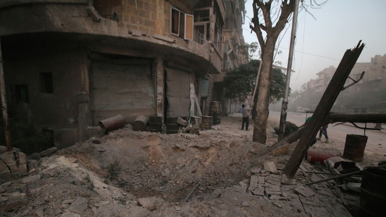 MIDEAST-CRISIS/SYRIA A man inspects damage near a hole in the ground after airstrikes on the rebel held al-Ansari neighbourhood of Aleppo, Syria October 2, 2016. REUTERS/Abdalrhman Ismail - RTSQFXT