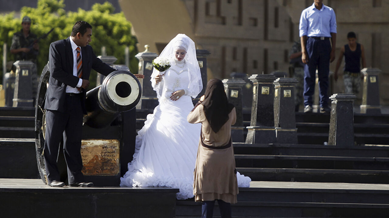 EGYPT-PROTESTS/ A bride and groom have their photos taken in front of the tomb of late Egyptian President Anwar al-Sadat and the Unknown Soldier monument, near a pro-Mursi protest camp in Rabaa Adawiya Square in Nasr City, east of Cairo August 11, 2013. REUTERS/Amr Abdallah Dalsh (EGYPT - Tags: POLITICS SOCIETY) - RTX12HG5