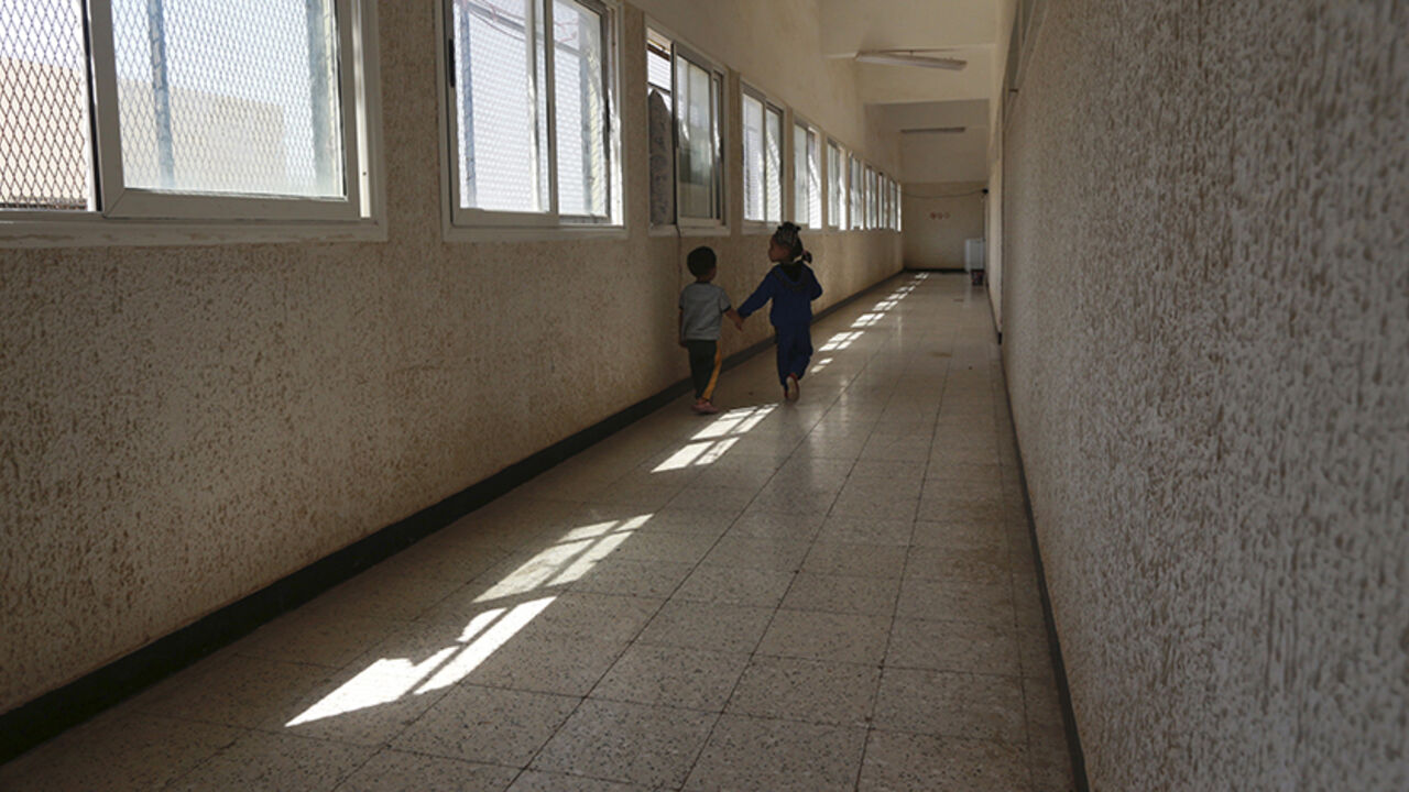 LIBYA-SECURITY/ Displaced children walk in a hallway at a school where their family has been taking refuge since clashes started between members of the Libyan pro-government forces, backed by the locals, and Shura Council of Libyan Revolutionaries, an alliance of former anti-Gaddafi rebels who have joined Islamist group Ansar al-Sharia, in Benghazi, Libya April 30, 2015. After a year of war, Libya's second-largest city Benghazi is divided into areas controlled by forces loyal to one of two rival Libyan governments, and are