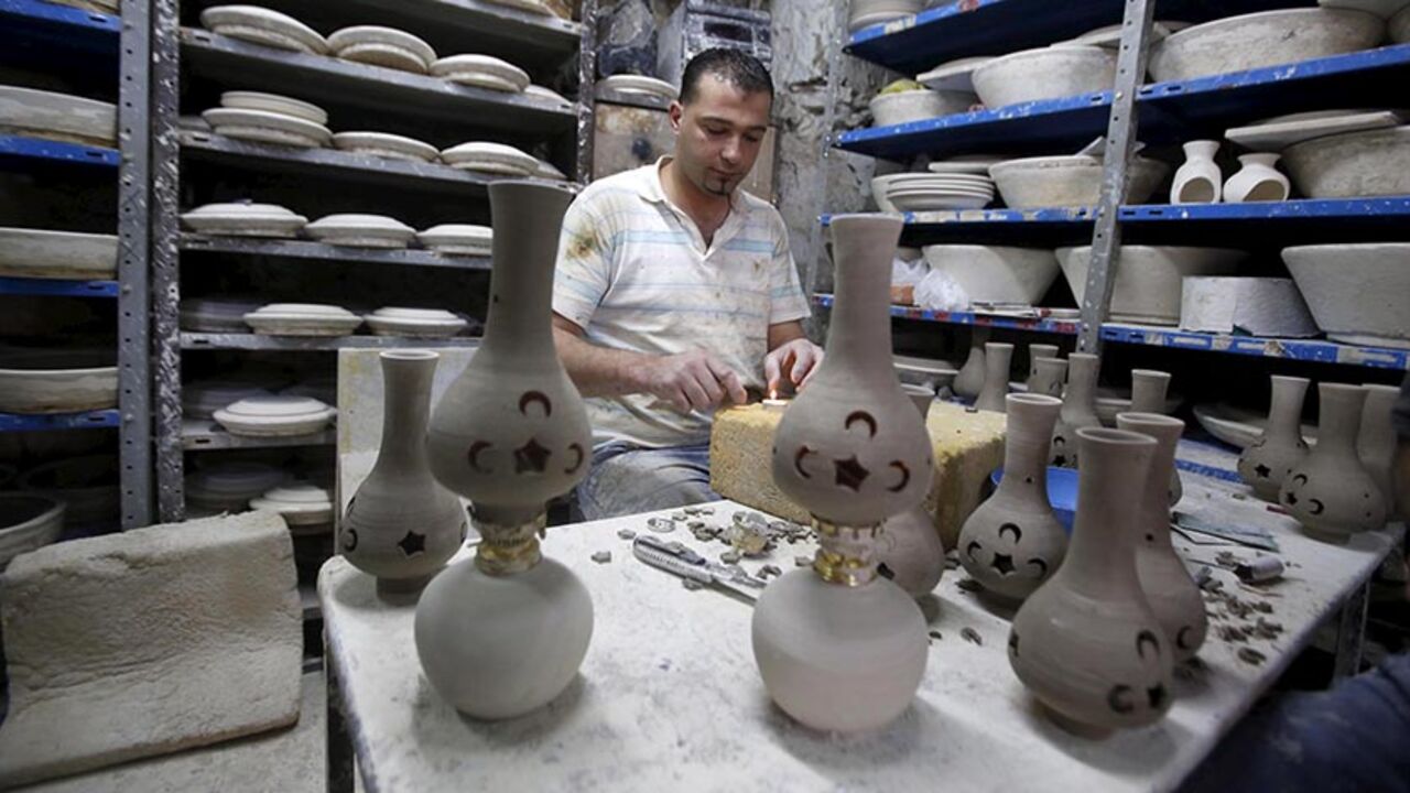 RELIGION-RAMADAN/ A Palestinian makes ceramic lamps used as decoration during the holy month of Ramadan in the old city of the West bank city of Hebron June 18, 2015. REUTERS/Mussa Qawasma - RTX1H2S8