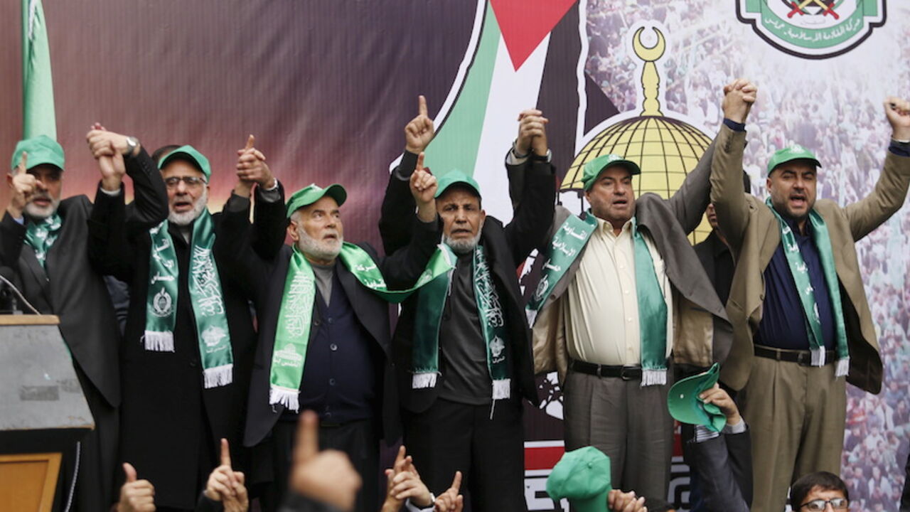 PALESTINIANS-ANNIVERSARY/ Senior Hamas leaders hold hands as they take part in a rally marking the 28th anniversary of Hamas' founding, in Gaza City December 14, 2015. REUTERS/Suhaib Salem - RTX1YLNL