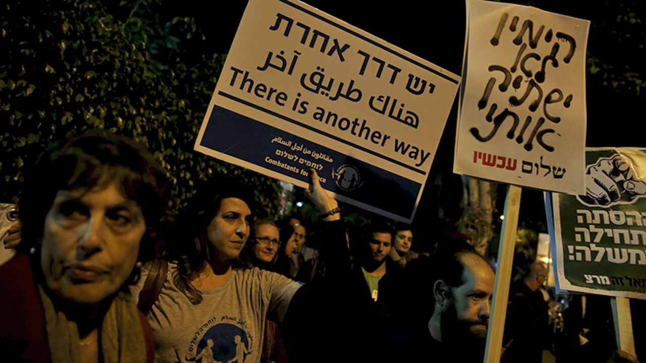 ISRAEL-NGOS-VIDEO Israeli left wing demonstrators march holding placards protesting the right wing incitement against President Reuven Rivlin and human rights activists in Tel Aviv. December 19, 2015. An ultra-nationalist Israeli group has published a video accusing the heads of four of Israel's leading human rights organisations of being foreign agents funded by Europe and supporting Palestinians "involved in terrorism". The sign (C) reads, "The right will not silence me." REUTERS/Baz Ratner - RTX1ZETU