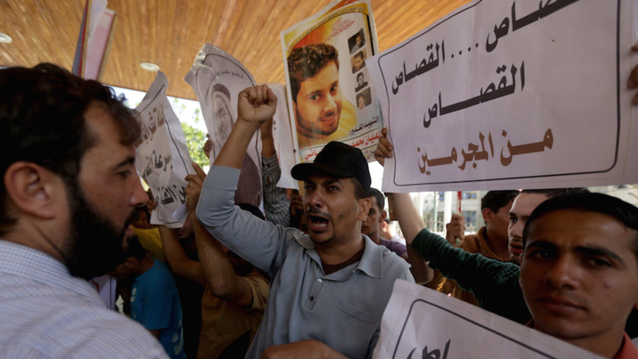 Nic6253719 Palestinian families of those killed in violence in the Gaza Strip, hold posters reading in Arabic: "punishment for criminals" as they protest in support of execution outside a conference being held by non-governmental organisations on the occasion of the World Day Against the Death Penalty, in Gaza City, on October 9, 2013. The Gaza Strip's Islamist rulers Hamas hanged a prisoner today who had been convicted of murder, its interior ministry said, despite international calls for a halt to executions. Under