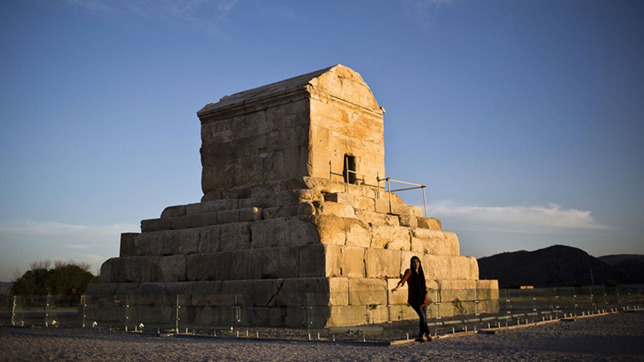 Nic6454771 An Iranian woman poses for a picture on May 19, 2015, in front of the tomb of Cyrus II of Persia, known as Cyrus the Great, the founder of the Persian Achaemenid Empire in 6th century BCE in the town of Pasargadae, 135 kilometers north east of the southern city of shiraz. Under his rule, the Achaemenid Empire created the largest empire the world had yet seen. Cuneiform records from Babylon suggest that Cyrus died on 4 December 530 BCE, but according to the Greek historian, Herodotus, Cyrus was killed near t