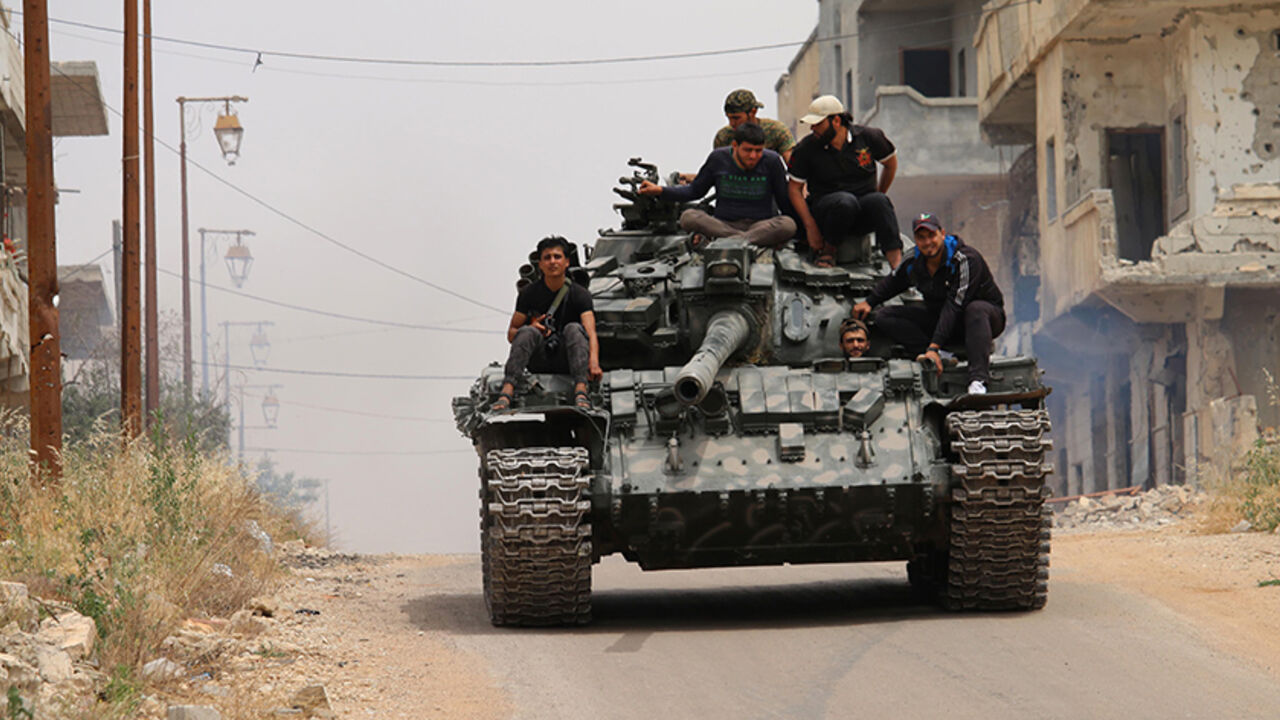 AFP_AF29D TOPSHOT - Opposition fighters drive a tank in a rebel-held area of the southern Syrian city of Daraa, during re-newed clashes with regime loyalists on May 10, 2016. / AFP / MOHAMAD ABAZEED (Photo credit should read MOHAMAD ABAZEED/AFP/Getty Images)