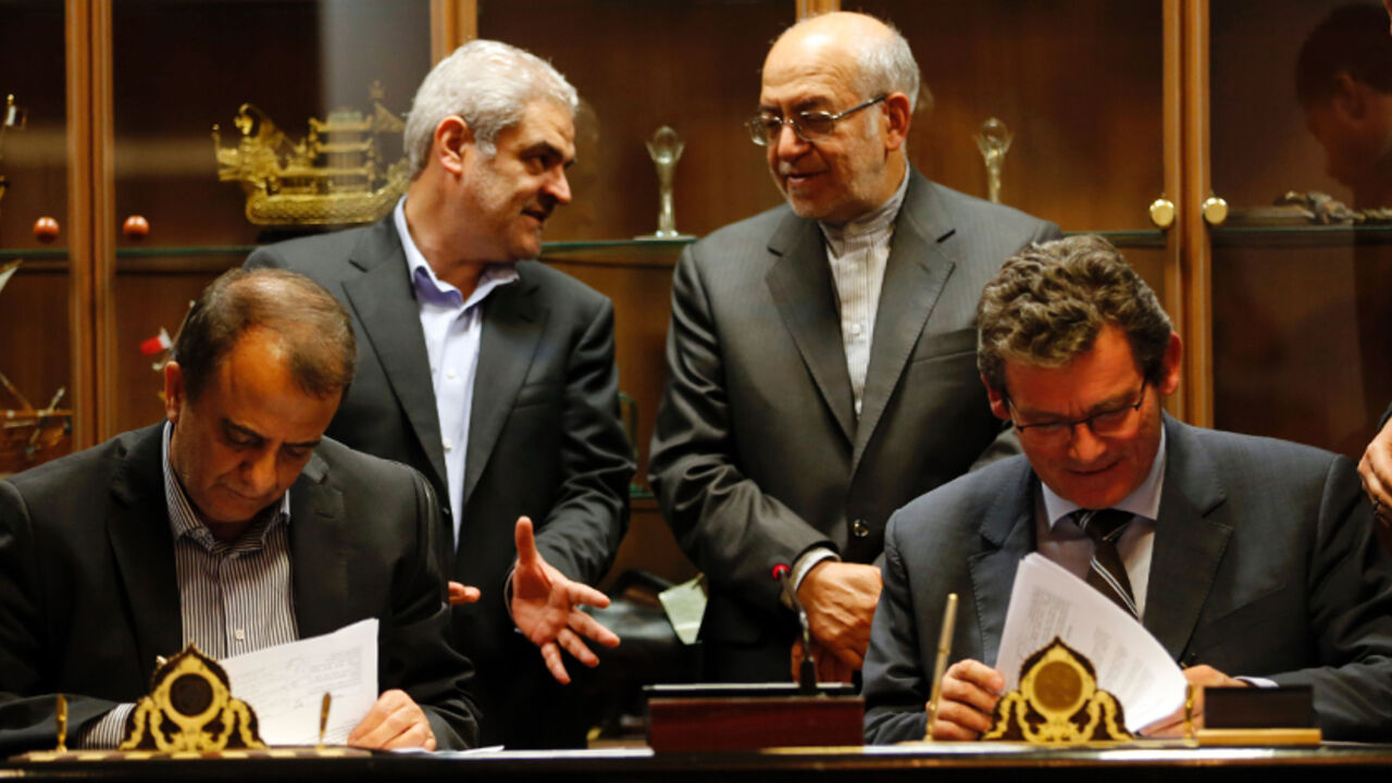 AFP_C70MV Deputy of France's Peugeot Citroen (PSA) Jean-Christophe Quemard,(R) signs documents with CEO of industrial group Iran Khodro, Hachem Yekehzare (L), as Iran's Industry and Commerce Minister Mohammad Reza Nematzadeh (2R) watches on in Tehran on June 21, 2016.
PSA is the first Western carmaker to announce a return to Iran since many economic sanctions were lifted in January when a landmark nuclear deal with world powers took effect.
/ AFP / ATTA KENARE (Photo credit should read ATTA KENARE/AFP/Getty I