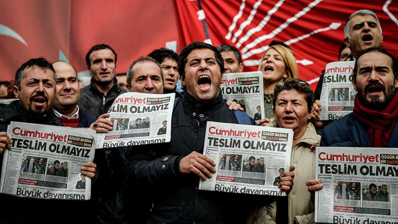 AFP_HO3G6 TOPSHOT - Protesters hold copies of the latest edition of the the Turkish daily newspaper "Cumhuriyet" as they shout slogans during a demonstration outside the newspaper's headquarters in Istanbul on November 1,2016 a day after its editor in chief was detained by police.
Turkish police detained the editor-in-chief of the opposition newspaper Cumhuriyet, state media reported, while the daily said several of its writers were taken into police custody. Murat Sabuncu was detained while authorities searched for