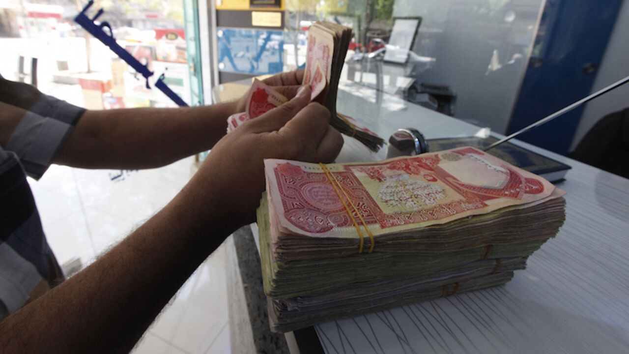 IRAQ-ECONOMY/DINAR A customer counts Iraqi dinars at a money changer in Baghdad October 1, 2012. Many Iraqis have lost faith in their dinar currency but to some foreign speculators, it promises big profits. The contrast underlines the uncertainties of investing in Iraq as the country recovers from years of war and economic sanctions. Picture taken October 1, 2012. To match IRAQ-ECONOMY/DINAR REUTERS/Saad Shalash (IRAQ - Tags: BUSINESS POLITICS) - RTR38QU1