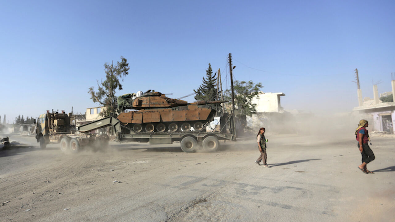 MIDEAST-CRISIS/SYRIA-TURKEY-ISLAMIC-STATE Free Syrian Army fighters walk past a Turkish tank mounted on a transporter in the northern Syrian rebel-held town of al-Rai, in Aleppo Governorate, Syria, October 5, 2016. REUTERS/Khalil Ashawi - RTSQWHS