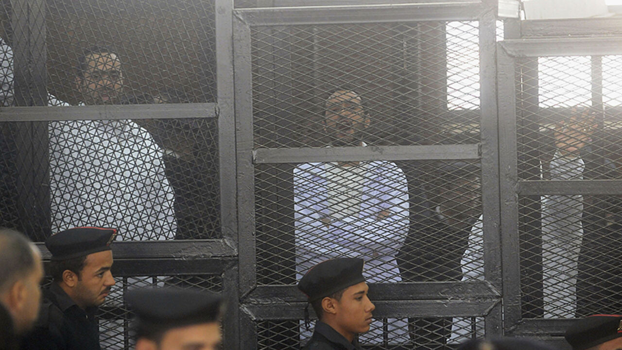 EGYPT-PROTESTS/ Political activists Ahmed Maher (R), Ahmed Douma (C) and Mohamed Adel, founder of 6 April movement, look on from behind bars in Abdeen court in Cairo, December 22, 2013. Three leading Egyptian activists were sentenced to three years in prison each on Sunday in a case brought over their role in recent protests, escalating a crackdown on dissent by the army-backed government. Maher, Douma and Adel are symbols of the protest movement that ignited the historic 2011 uprising against President Hosni Mubarak. Each