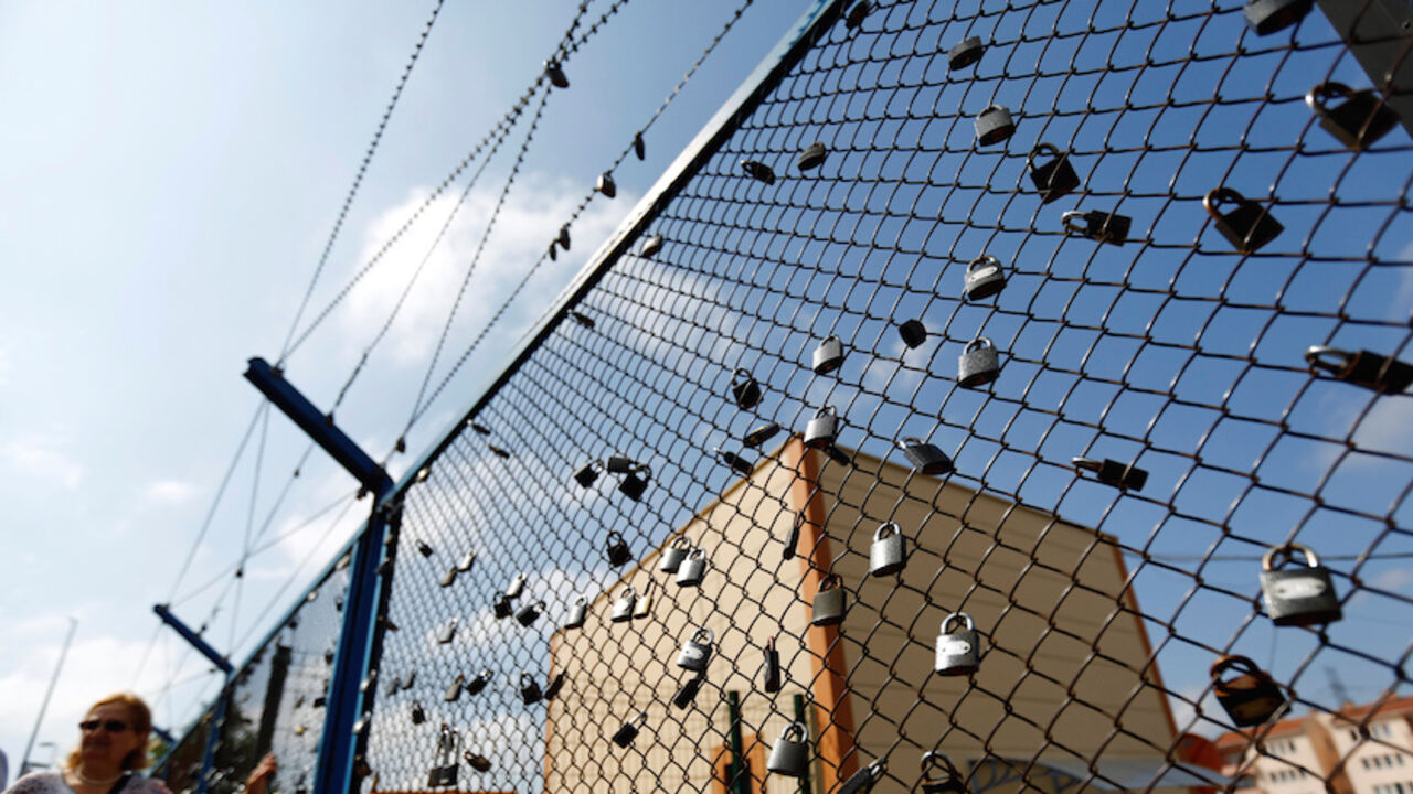 TURKEY-MEDIA/ A demonstrator stands next to a fence with padlocks left by prisoners, during a protest against the arrest of three prominent activists for press freedom, in front of Metris prison in Istanbul, Turkey, June 24, 2016. REUTERS/Murad Sezer - RTX2HYKN
