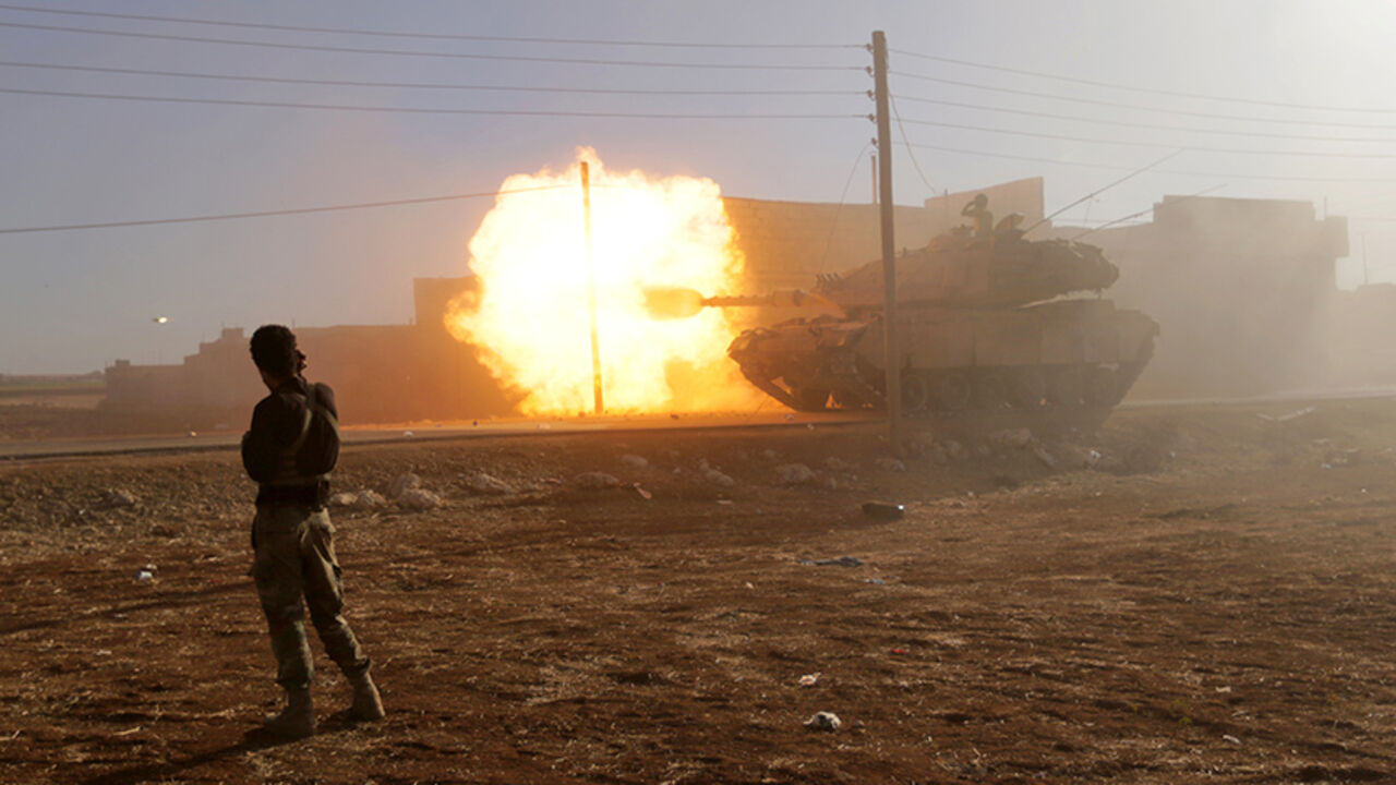 MIDEAST-CRISIS/SYRIA A rebel fighter stands near a Turkish tank as it fires towards Guzhe village, northern Aleppo countryside, Syria October 17, 2016. REUTERS/Khalil Ashawi TPX IMAGES OF THE DAY - RTX2P879