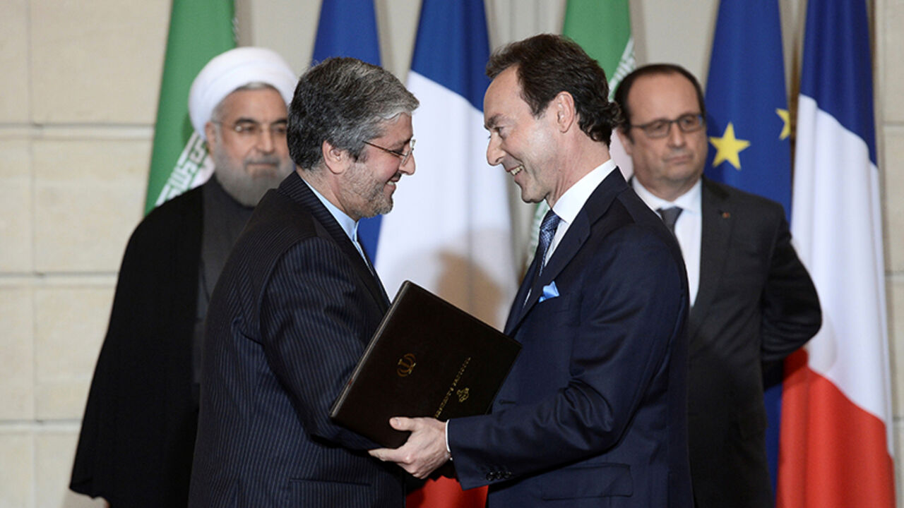 IRAN-AIRCRAFT/ Airbus chief executive Fabrice Bregier (R), Iran Air chief Executive Farhad Parvaresh (L), Iranian President Hassan Rouhani (rear L) and French President Francois Hollande attend a bilateral political, cultural and economic agreements signing ceremony at the Elysee Palace in Paris, France, January 28, 2016.REUTERS/Stephane De Sakutin/Pool/Files - RTX2SAMN